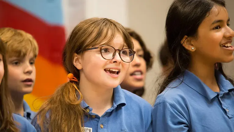 young girls in blue polo shirts singing