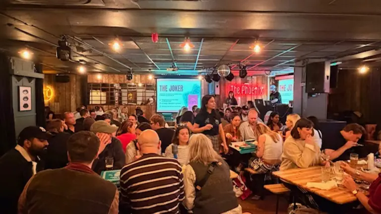 Large groups of people in a bar doing a pub quiz