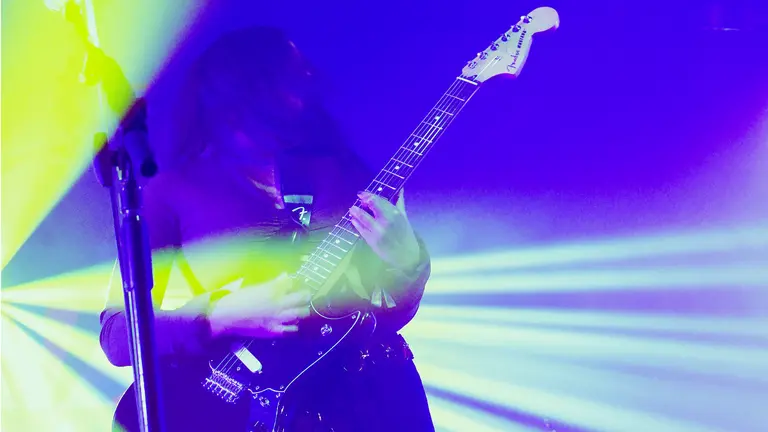 strobe lights filter a guitarist in blue and yellow lighting