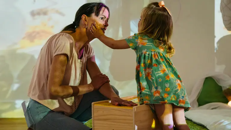 An early years child playing with an adult at a project