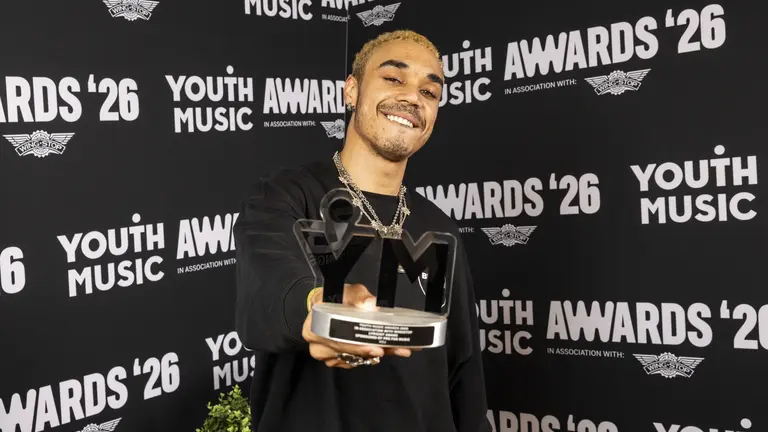 KOJ showing his Youth Music Award and smiling