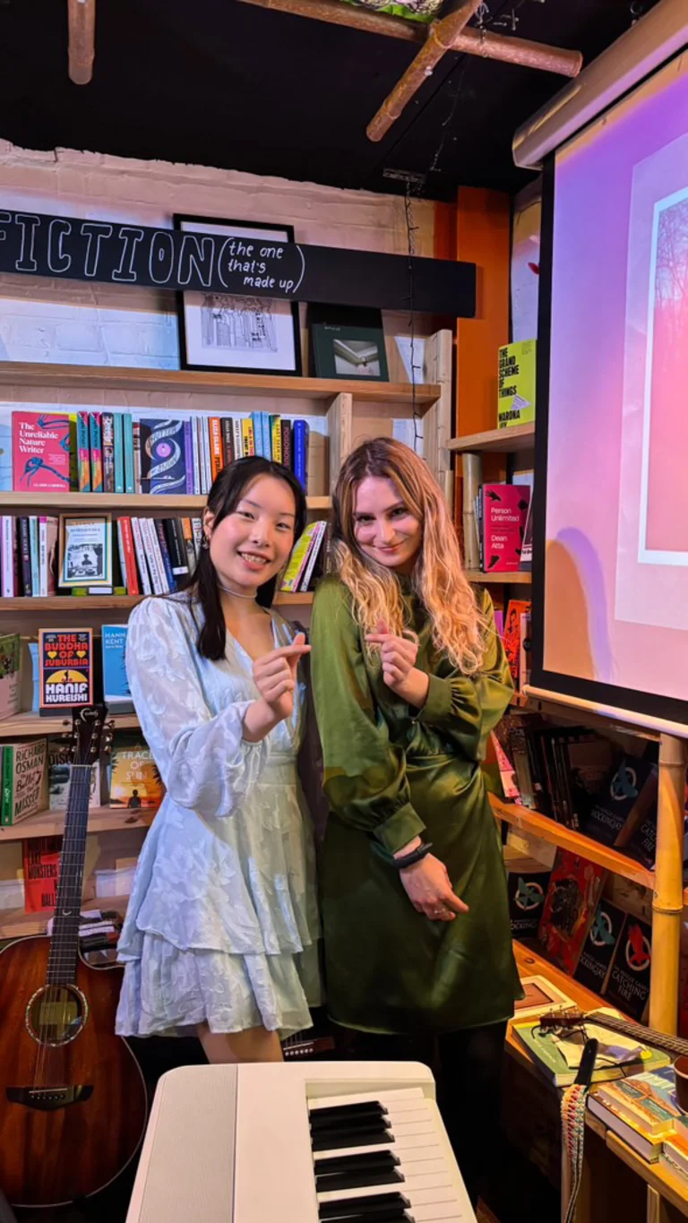 monica wat and cat rose pose together, making heart signs with one hand