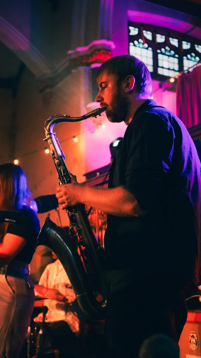 a member of george bloomfield's band plays saxophone on stage
