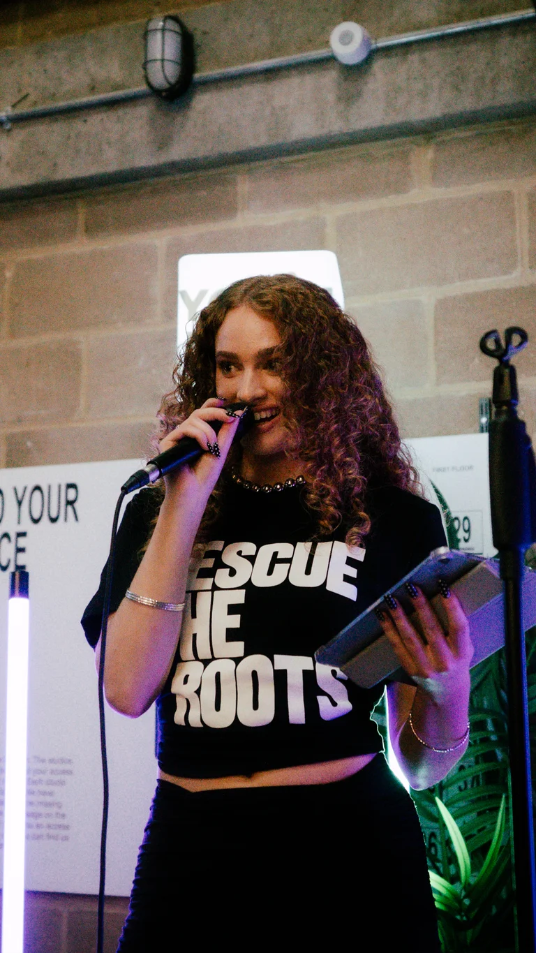 livvy k performs in a rescue the roots t-shirt
