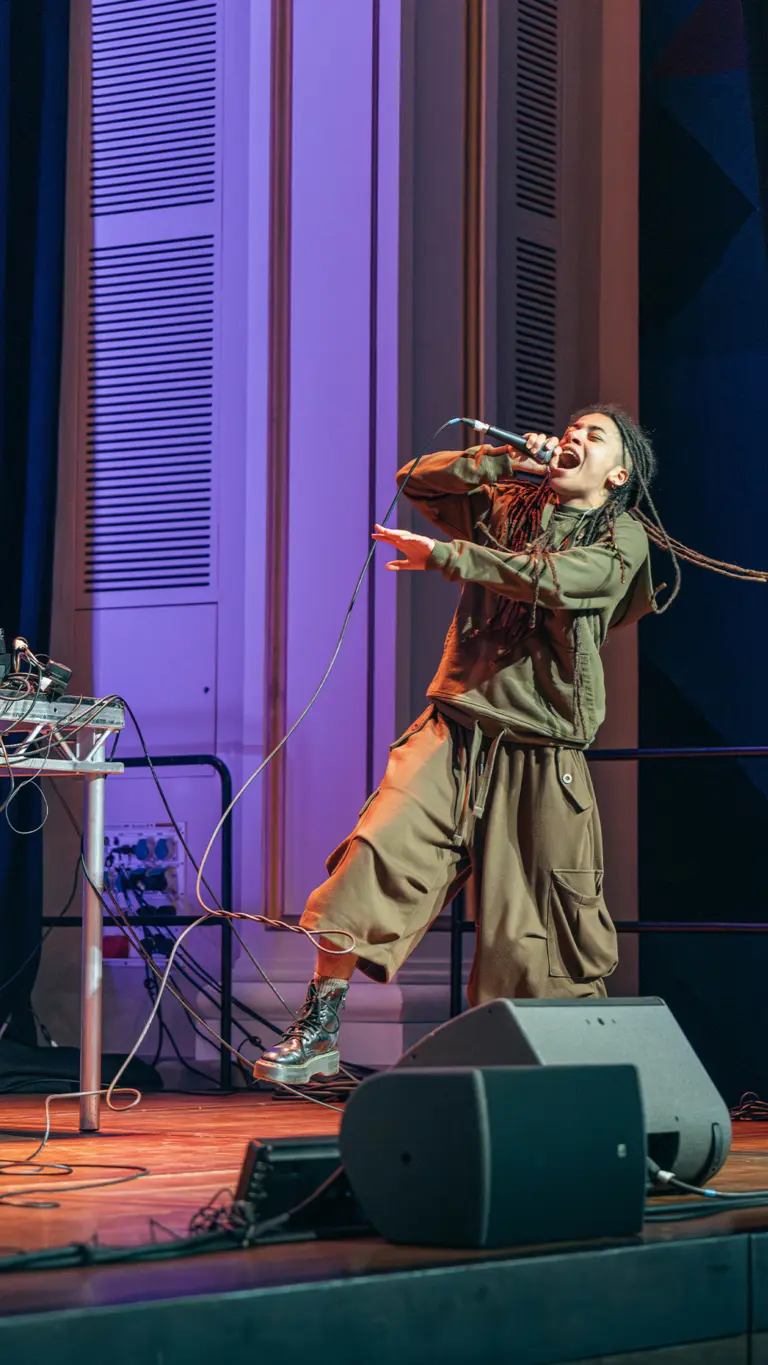 a person performs energetically on stage with a microphone