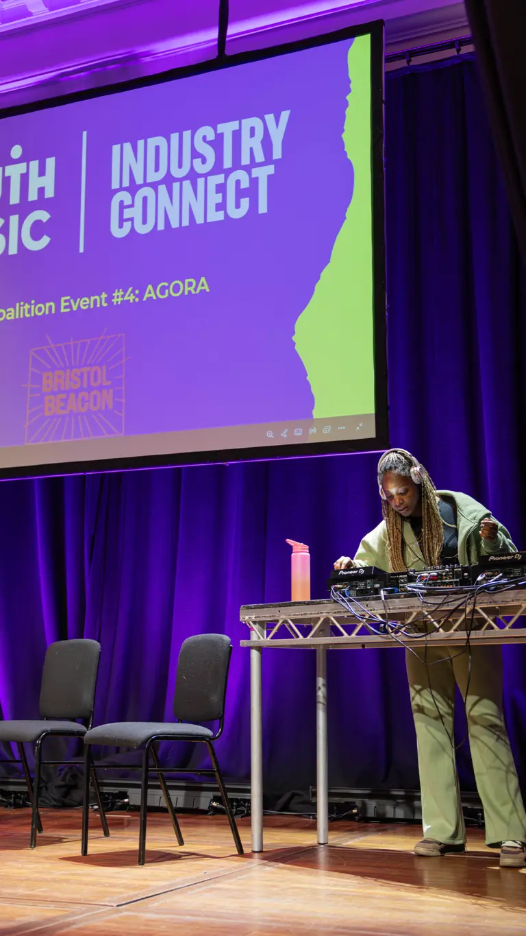 a dj plays decks on stage