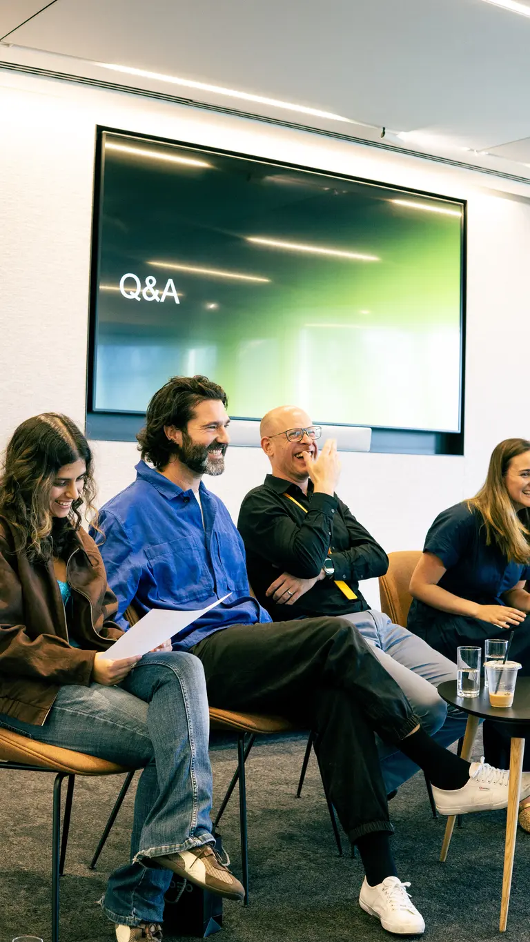 people smile while seated as part of a panel