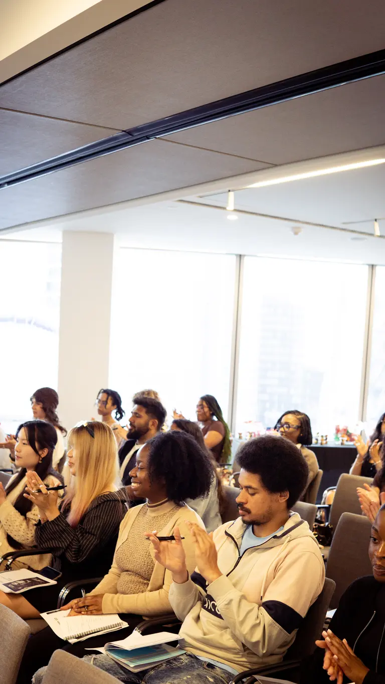 a room of seated people clapping