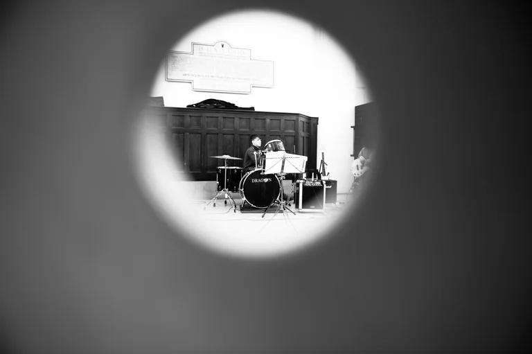 a drum kit is photographed through a circle in black and white