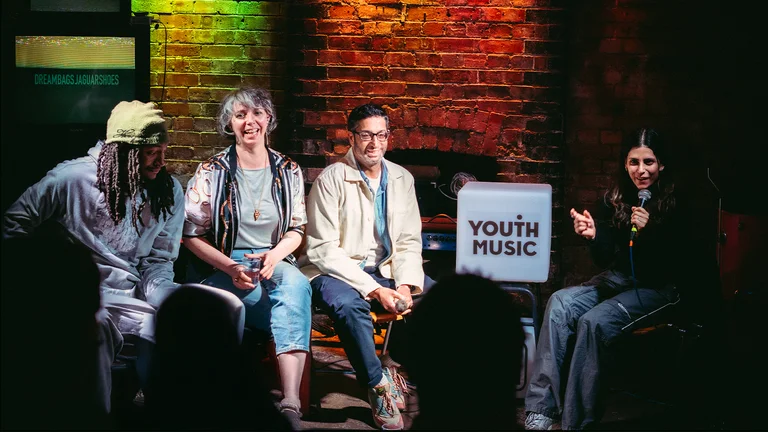 a panel of people sit on a stage