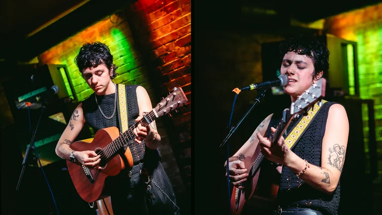 eden howells plays the acoustic guitar and sings on stage