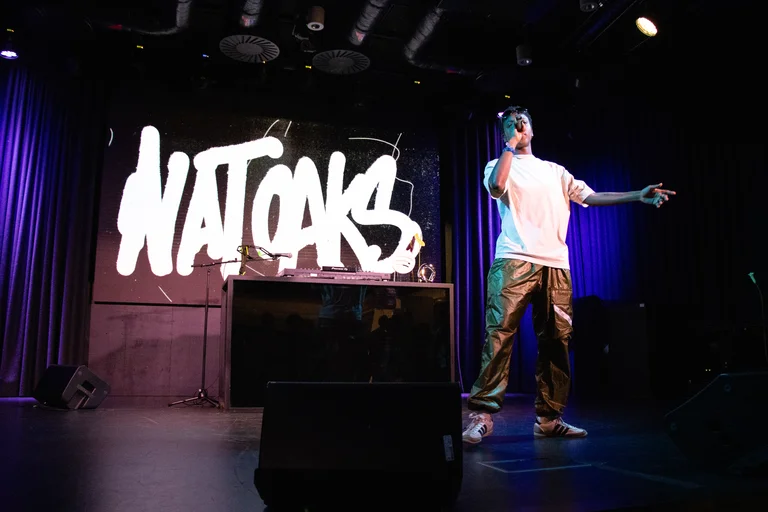 image of nat oaks performing in front of their name lit up