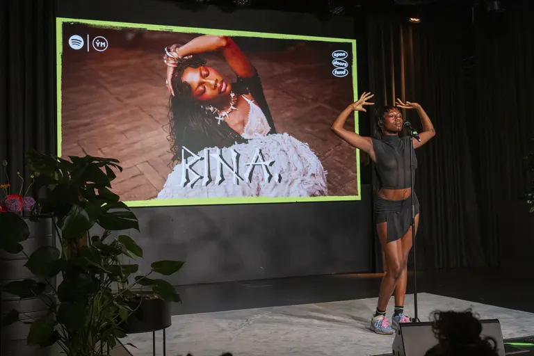 BINA performing on stage wearing all black