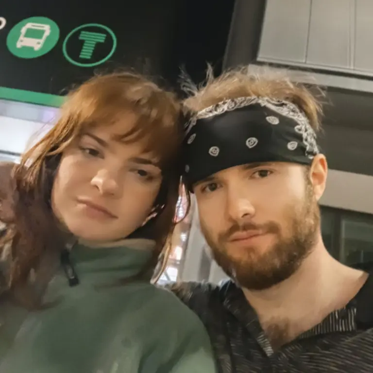 Hannah Paloma and James Jones posing for a selfie. Hannah is wearing a zipped up green fleece and James a dark blue bandana