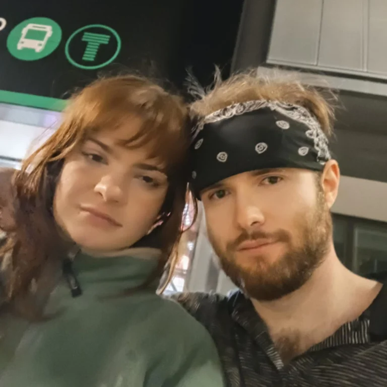 Hannah Paloma and James Jones posing for a selfie. Hannah is wearing a zipped up green fleece and James a dark blue bandana