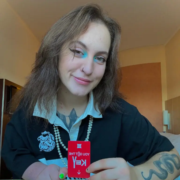Keys (Rightkeysonly) posing for a photo and smilng, with an open white colour, navy blue jumper and smiling