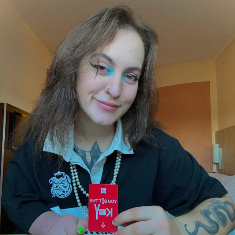 Keys (Rightkeysonly) posing for a photo and smilng, with an open white colour, navy blue jumper and smiling