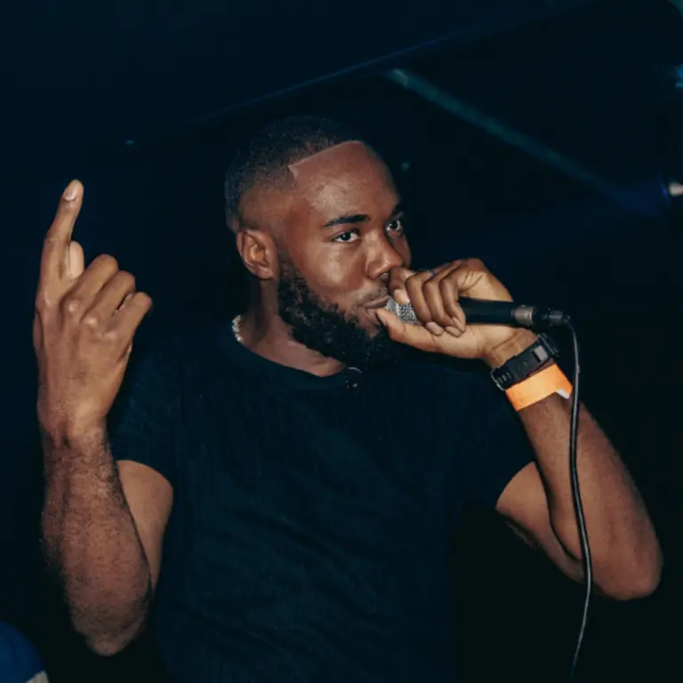 Righteous Reck performing on stage into a microphone